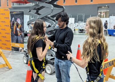 Students putting on safety harnesses at LiUNA! Local 837 booth - Epic Jobs 2024